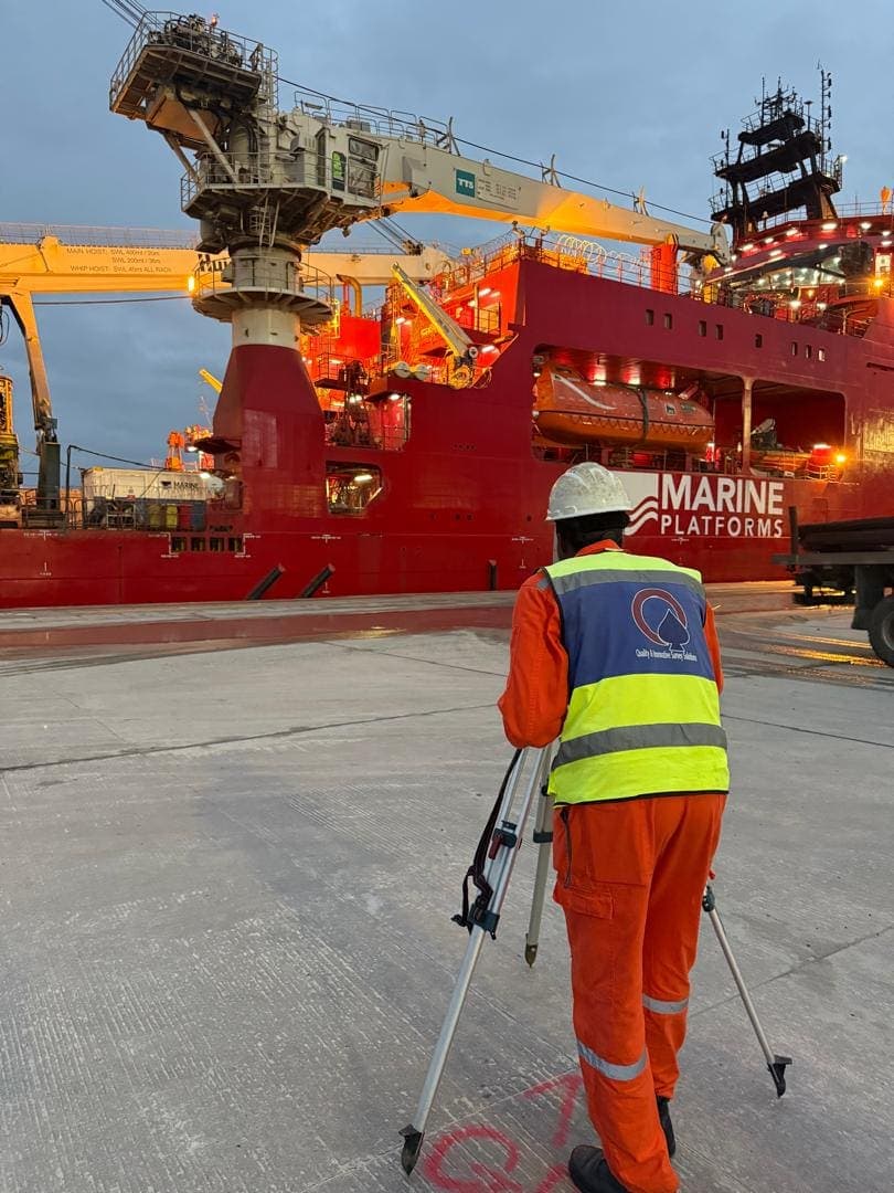 Surveyor with a total station in front of a Marine Platforms vessel